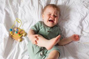 Baby,In,A,Green,Cotton,Bodysuit,Is,Crying,Lying,In liability defective child toys
